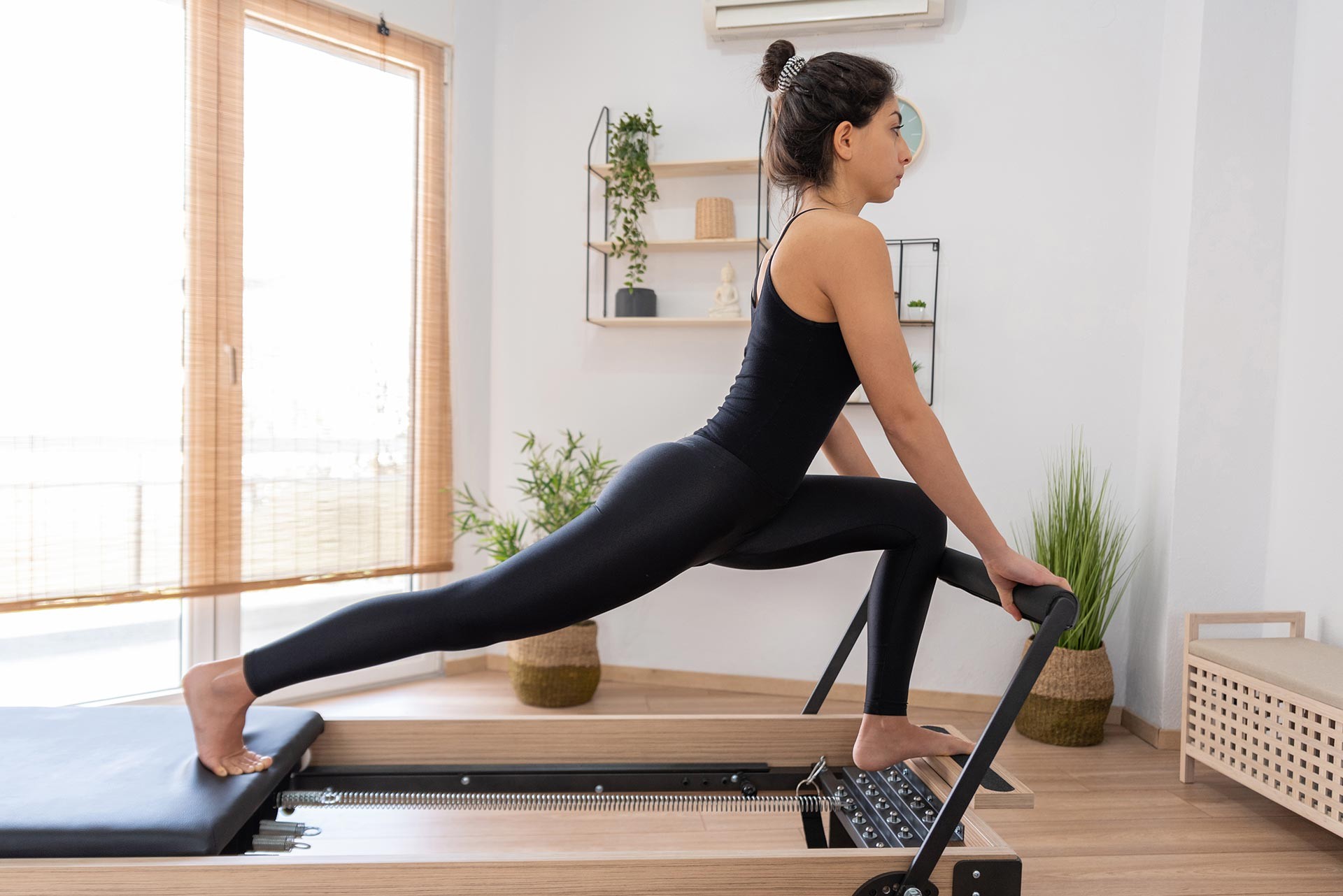 young-woman-exercising-on-pilates-reformer-bed-2021-08-26-15-59-35-utc-(1)